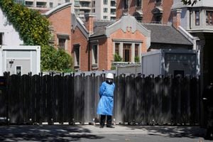 Un guardia de seguridad con un traje protector hace guardia frente a una puerta, luego del brote de la enfermedad coronavirus (COVID-19), en Shanghái, China, el 10 de octubre de 2022. 