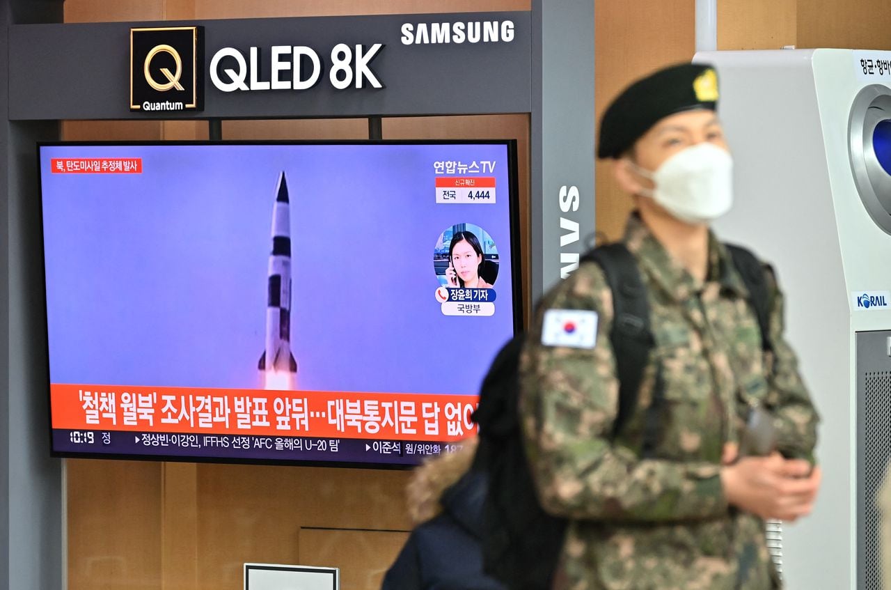Un soldado surcoreano pasa junto a una pantalla de noticias de televisión que muestra imágenes de archivo de una prueba de misiles de Corea del Norte, en una estación de tren en Seúl el 5 de enero de 2022.