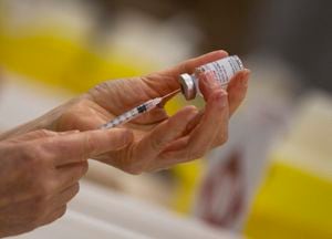 Un farmacéutico llena una jeringa con la vacuna de Moderna contra el Coronavirus. (AP Foto/Virginia Mayo, FILE)