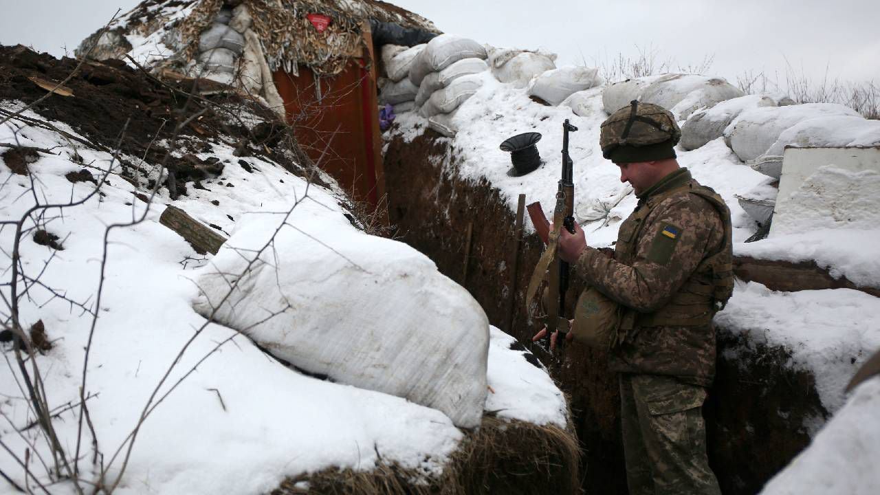 Un militar de las Fuerzas Militares de Ucrania revisa su arma mientras está de pie en una trinchera en la línea del frente con los separatistas respaldados por Rusia cerca de la aldea de Zolote, en la región oriental de Lugansk. (AFP /Anatolii Stepanov)