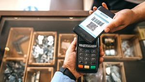 El propietario de la tienda recibe un pago sin contacto mediante una aplicación de teléfono móvil y un lector de tarjetas de crédito al finalizar la compra