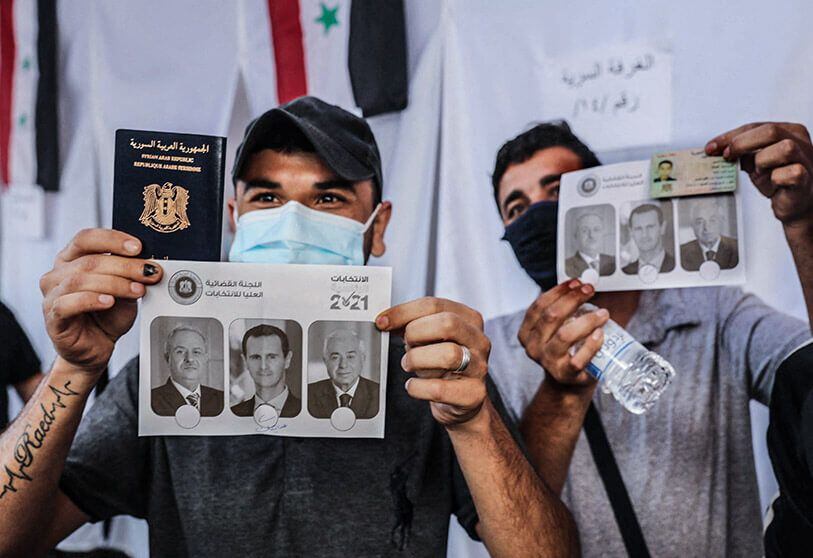 AFP/ANWAR AMRO - Votantes sirios residentes en Líbano muestran imágenes de los candidatos a las próximas elecciones presidenciales en su país tras registrarse para votar en la embajada siria en las afueras de la capital libanesa, Beirut, el 20 de mayo de 2021