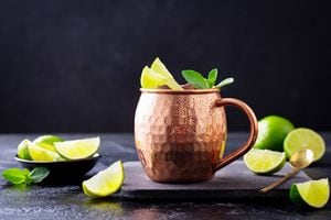 Cóctel Moscow Mule con cerveza de jengibre, vodka, lima y menta. Fondo oscuro. De cerca.