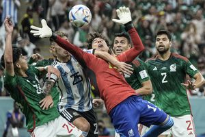 El portero mexicano Guillermo Ochoa busca el balón durante el partido de fútbol del grupo C de la Copa Mundial entre Argentina y México, en el Estadio Lusail en Lusail, Qatar, el sábado 26 de noviembre de 2022.