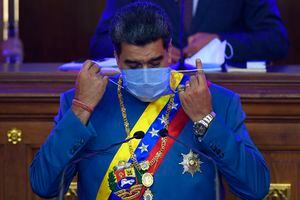 El presidente de Venezuela Nicolás Maduro se retira la mascarilla mientras se alista para su informe anual a la nación ante legisladores de la Asamblea Nacional en Caracas, el martes 12 de enero de 2021. (AP Foto/Matias Delacroix)