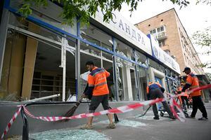 Trabajadores barren vidrios rotos en un edificio dañado luego de un ataque con drones en Moscú, Rusia, el lunes 24 de julio de 2023.