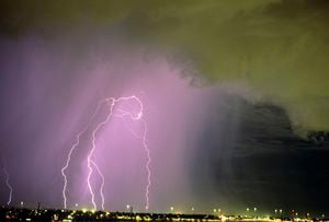 Célula de tormenta activa sobre la ciudad con nubes en primer plano y una cortina de lluvia detrás, que contiene múltiples descargas de rayos de nube a tierra, Tucson, Arizona, EE. UU.