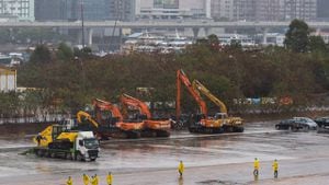 El equipo de construcción camina bajo la lluvia en el sitio de una instalación de aislamiento temporal para albergar a pacientes con coronavirus Covid-19 en Kai Tak en Hong Kong el 20 de febrero de 2022.