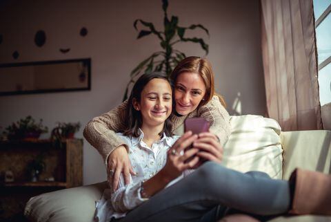 Madre e hija usando un celular