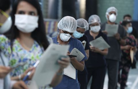 Enfermeras y médicos esperan en la fila para recibir una inyección de la vacuna Sinopharm de China durante una campaña prioritaria de vacunación COVID-19 en un hospital público en Lima, Perú. (AP Foto/Martin Mejia)
