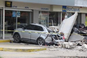 Los vehículos dañados por el derrumbe de la fachada de una tienda por departamentos durante un terremoto se muestran en Manzanillo, México 19 de septiembre de 2022.