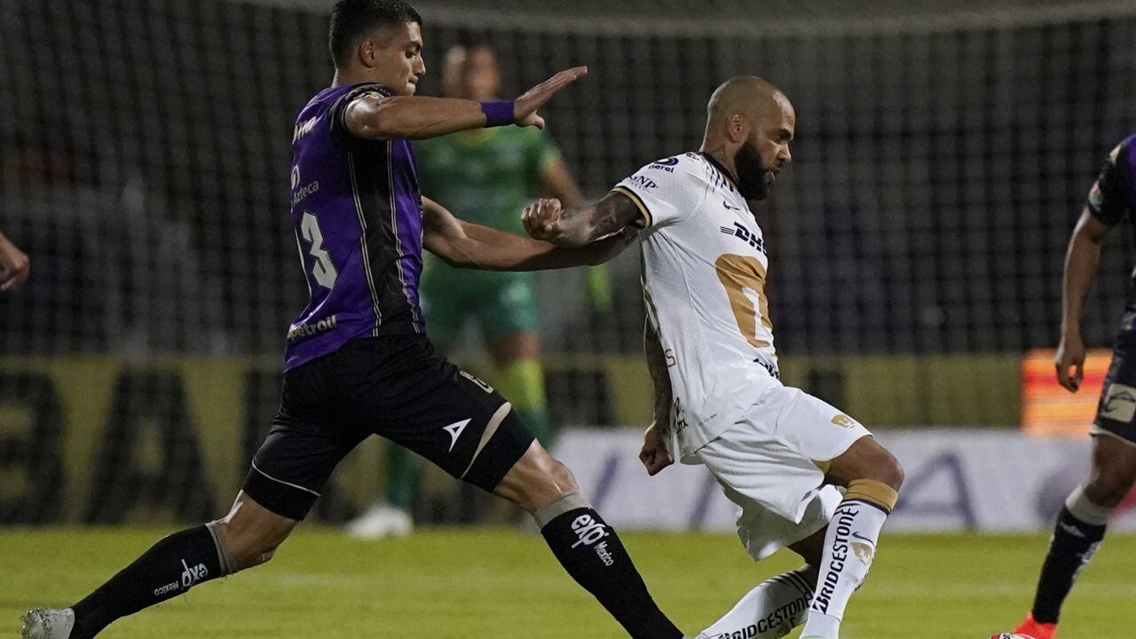 El brasileño Dani Alves, de Pumas, disputa un balón con Alan López, de Mazatlán, durante un partido de la Liga MX, el miércoles 27 de julio de 2022 (AP/Eduardo Verdugo)