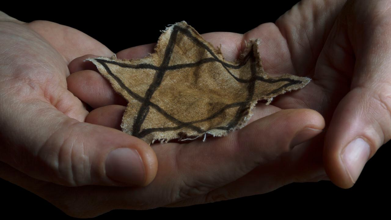 Primer plano de una insignia judía irregular en manos de un hombre