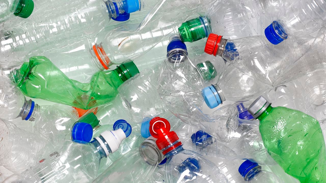 botellas de agua usadas desechadas en la papelera de reciclaje. Las tapas también se pueden reciclar si se vuelven a colocar en la botella de agua.