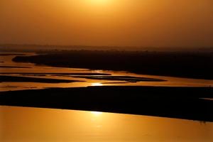 El sol se puso en la cuenca del río Ganges, uno de los ríos más sagrados de la India con niveles decrecientes de agua en sus tramos más bajos en el Día mundial de la Tierra en Prayagraj, India, el jueves 22 de abril de 2021. Foto: AP / Rajesh Kumar Singh.