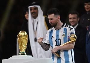 Soccer Football - FIFA World Cup Qatar 2022 - Final - Argentina v France - Lusail Stadium, Lusail, Qatar - December 18, 2022  Argentina's Lionel Messi looks at the World Cup trophy after receiving the Golden Ball award REUTERS/Dylan Martinez