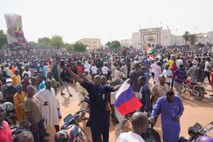 Los nigerianos, algunos con banderas rusas, participan en una marcha convocada por los partidarios del líder golpista, el general Abdourahmane Tchiani, en Niamey, Níger, el domingo 30 de julio de 2023. Días después de que soldados amotinados derrocaran al presidente elegido democráticamente de Níger, aumenta la incertidumbre sobre la situación del país.