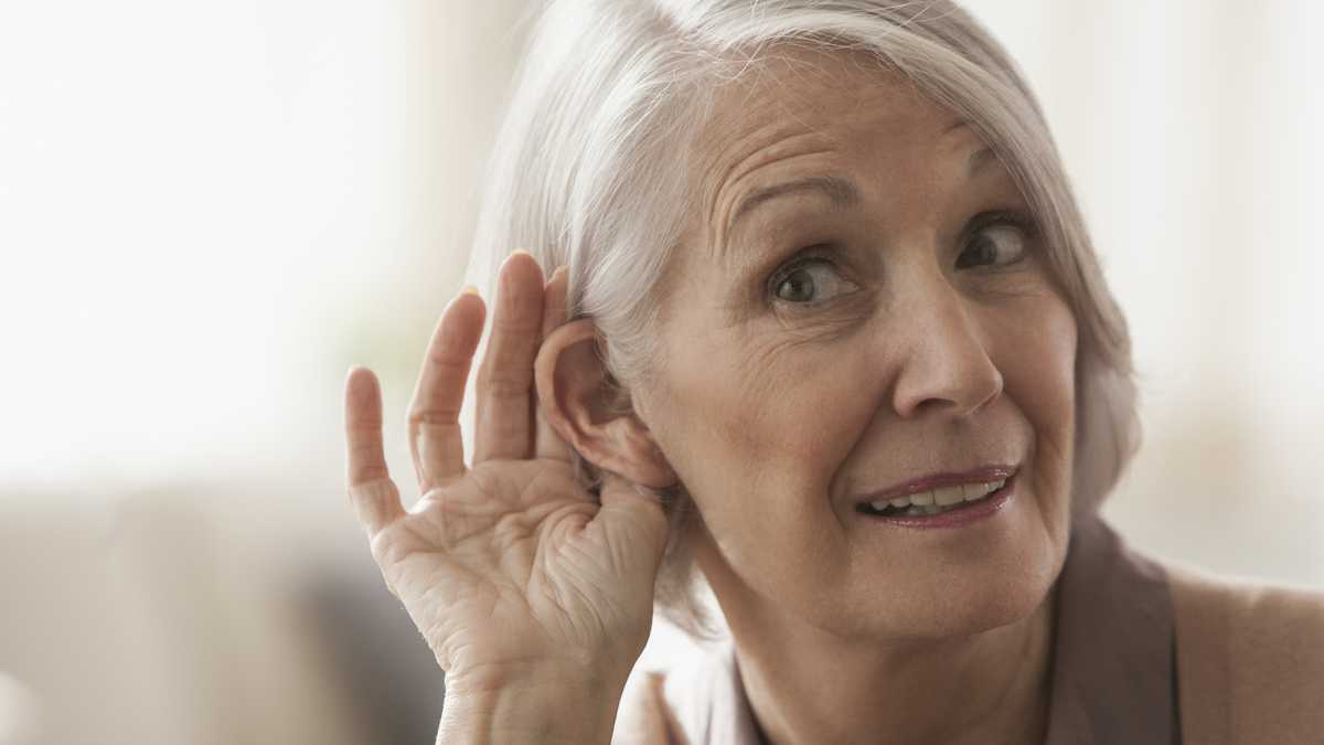 Senior Caucasian woman cupping her ear to listen