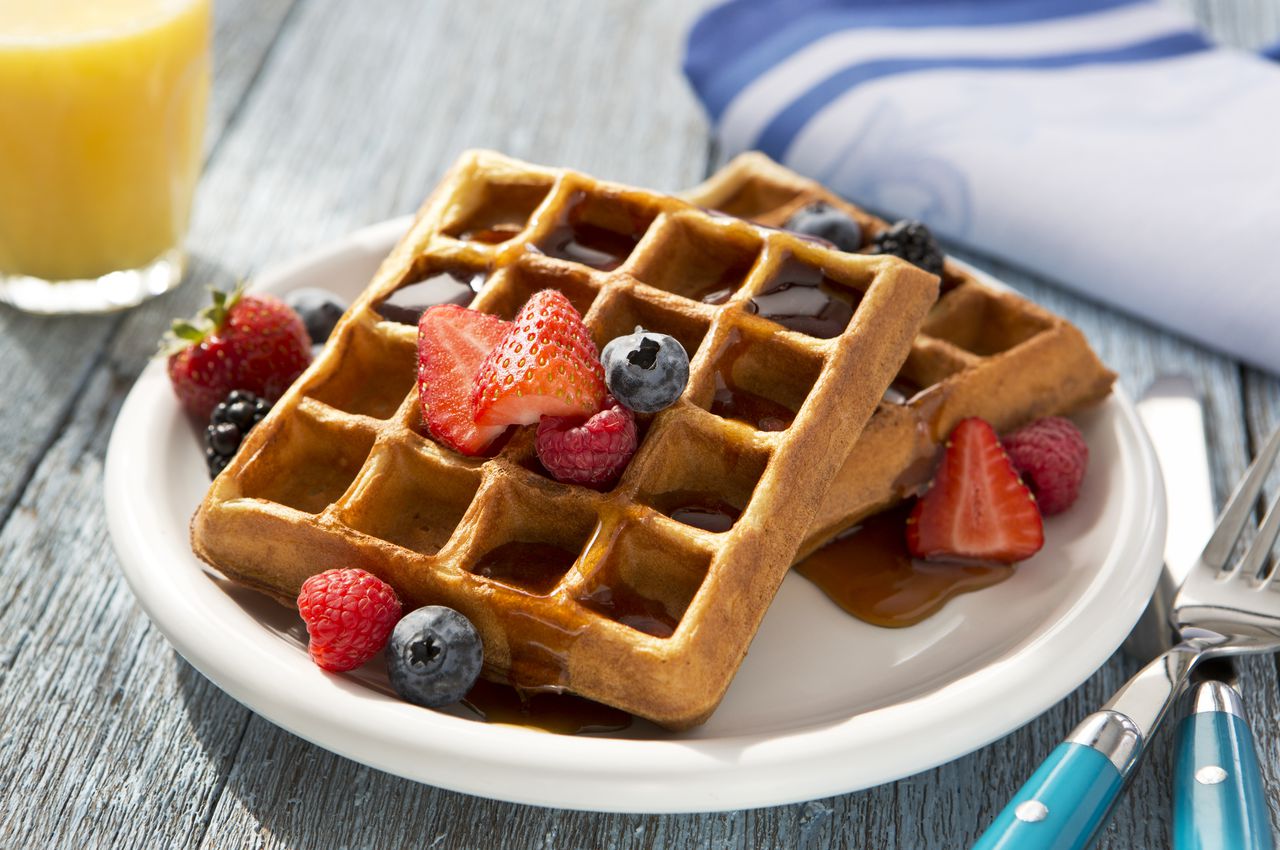 Waffles saludables para el desayuno con mezcla de toppings nutritivos como fresas y arándanos.