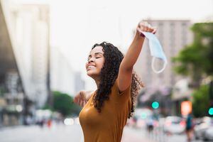 Quitándose la mascarilla para respirar un poco de aire fresco en un parque público tapabocas