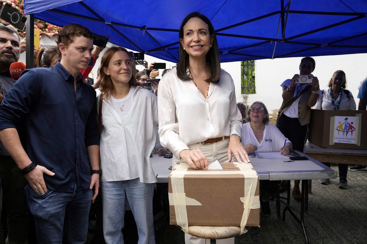 La aspirante presidencial de la oposición María Corina Machado vota durante las elecciones primarias de la oposición mientras sus hijos esperan en Caracas, Venezuela, el domingo 22 de octubre de 2023.