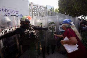 Una mujer rocía graffiti en una marcha para exigir justicia para las víctimas de violencia de género y feminicidios tras la muerte de Debanhi Escobar, una estudiante de derecho de 18 años cuyo cuerpo fue encontrado sumergido en un tanque de agua dentro de los terrenos de un motel en el estado norteño de Nuevo León, en la Ciudad de México, México 24 de abril de 2022. Foto REUTERS/Quetzalli Nicte-ha