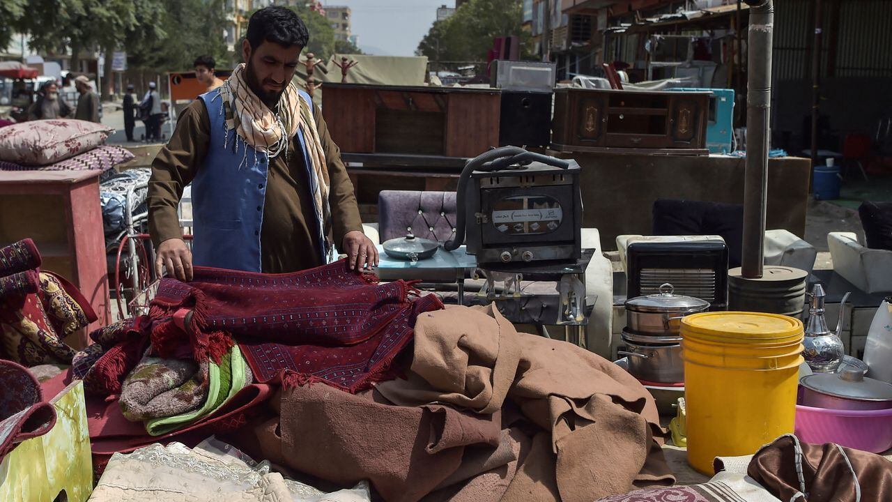 Esta foto tomada el 12 de septiembre de 2021 muestra a un hombre mirando artículos domésticos de segunda mano a la venta en un mercado en el barrio noroeste de Khair Khana en Kabul. - Los mercados de pulgas de Kabul están repletos de pertenencias que afganos desesperados han vendido a precios bajísimos para financiar largos viajes para escapar del país o simplemente para pagar la comida. (Foto de WAKIL KOHSAR / AFP) / PARA IR CON Afganistán-conflicto-mercados de pulgas, FOCUS por James EDGAR
