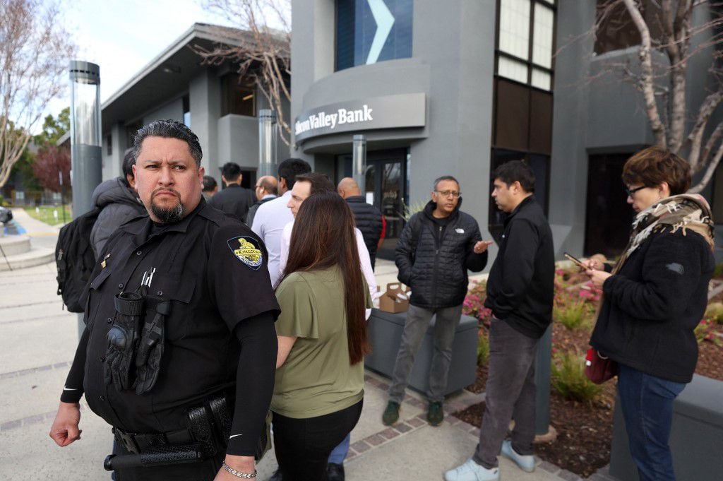 Un guardia de seguridad monitorea una fila de personas afuera de una oficina de Silicon Valley Bank el 13 de marzo de 2023 en Santa Clara, California (Foto de JUSTIN SULLIVAN/GETTY IMAGES NORTH AMERICA/Getty Images vía AFP)
