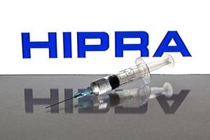 SPAIN - 2021/08/26: In this photo illustration, a medical syringe seen in front of the Hipra, S.A. logo. (Photo Illustration by Thiago Prudencio/SOPA Images/LightRocket via Getty Images)