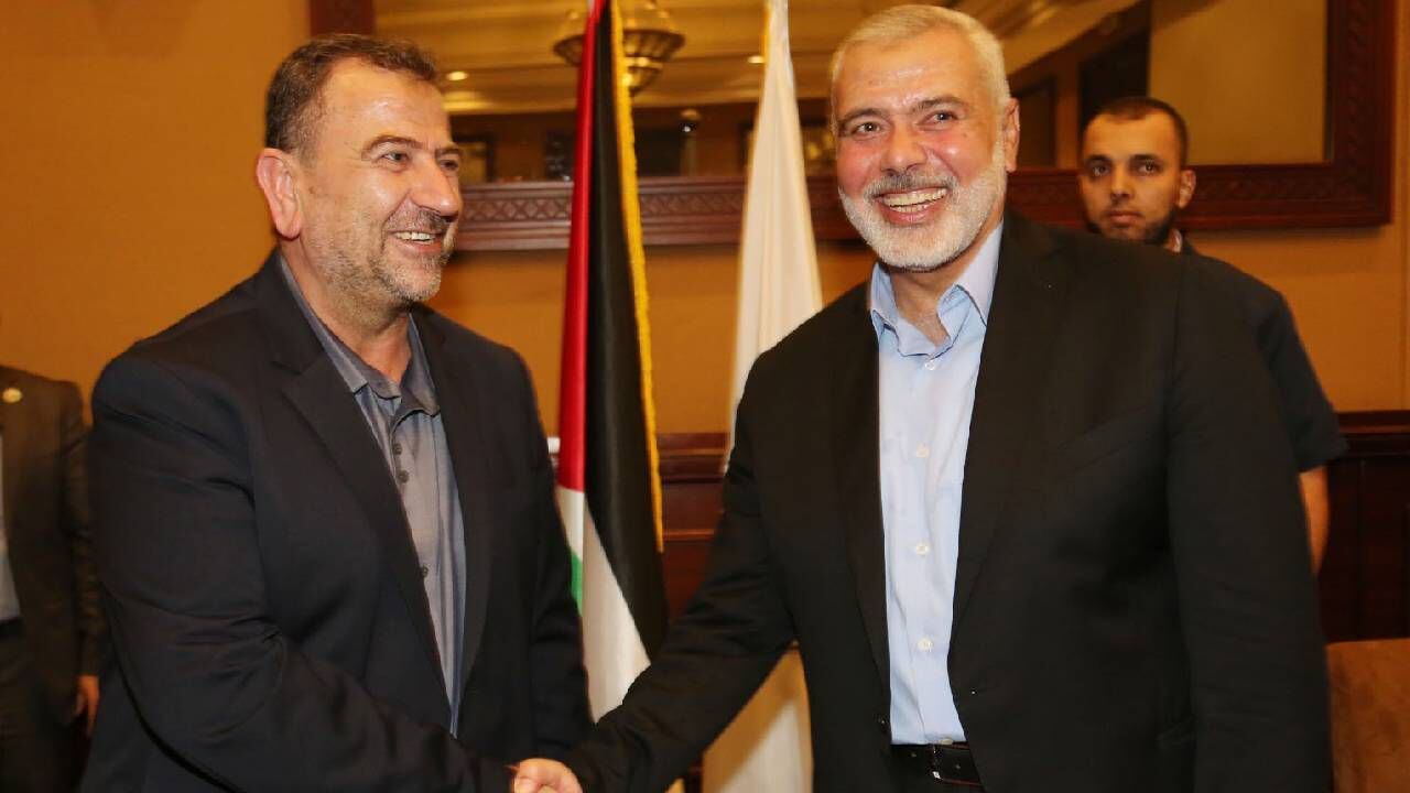 Jefe del Buró Político de Hamás, Ismail Haniyeh (R), le da la mano a Saleh Aruri.