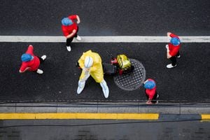 Los trabajadores con trajes protectores toman un descanso en una calle después de las pruebas de ácido nucleico durante el encierro, en medio de la pandemia de la enfermedad por coronavirus, en Shanghái, China, el 26 de abril de 2022. Foto REUTERS/Aly Song 