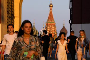Varias personas, en su mayoría sin mascarilla, caminan por la Plaza Roja al atardecer, en Moscú, Rusia, el 24 de junio de 2021. (AP Foto/Alexander Zemlianichenko)