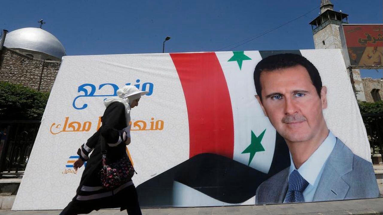 Transeúntes pasan delante de los afiches electorales de Bashar al Asad, el 25 de mayo de 2021 en Damasco LOUAI BESHARA AFP