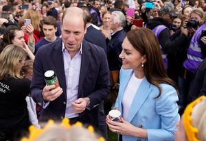 WINDSOR, ENGLAND - MAY 07: Prince William, Prince of Wales holds a can of 'Return of the King' Coronation Ale as he stands next to Catherine, Princess of Wales as they speak to people during a walkabout meeting members of the public on the Long Walk near Windsor Castle, where the Coronation Concert to celebrate the coronation of King Charles III and Queen Camilla is being held this evening on May 7, 2023 in Windsor, England. The Coronation of Charles III and his wife, Camilla, as King and Queen of the United Kingdom of Great Britain and Northern Ireland, and the other Commonwealth realms took place yesterday at Westminster Abbey today. Charles acceded to the throne on 8 September 2022, upon the death of his mother, Elizabeth II.  (Photo by Andrew Matthews-WPA Pool/Getty Images)