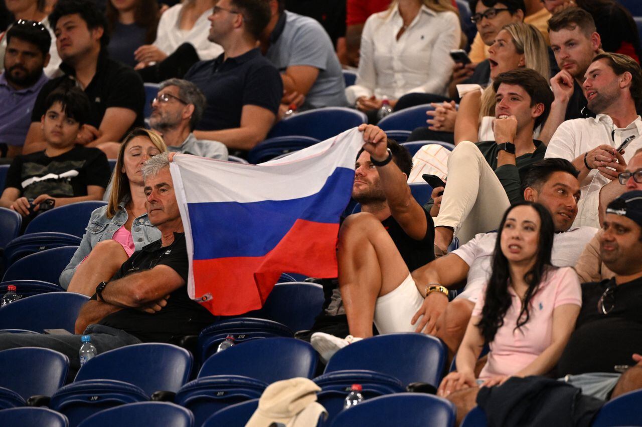 A supporter holds a flag of Russia during the men's singles match between Marcos Giron of the US and Russia's Daniil Medvedev on day one of the Australian Open tennis tournament in Melbourne on January 16, 2023. (Photo by WILLIAM WEST / AFP) / -- IMAGE RESTRICTED TO EDITORIAL USE - STRICTLY NO COMMERCIAL USE --