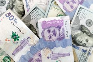 Primer plano de billetes de 50 mil pesos colombianos y billetes de 100 dólares