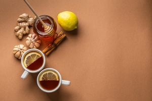 Natural cold, flu home remedies: hot tea cups with lemon, honey, ginger, garlic to boost immune system. Natural healthy food ingredients for immunity stimulation, against viruses. Top view, copy space