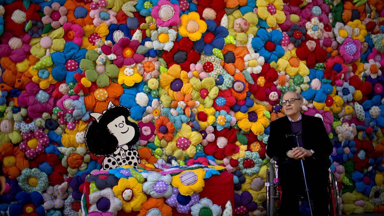 FILE - In this Sept. 15, 2014 file photo, Argentine cartoonist Joaquin Salvador Lavado, better known as "Quino," poses next to his character Mafalda at the exhibition, The World According to Mafalda, in Buenos Aires, Argentina. Lavado passed away on Wednesday, Sept. 30, 2020, according to his editor Daniel Divinsky who announced it on social media. (AP Photo/Natacha Pisarenko, File)