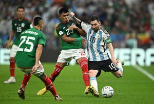 Soccer Football - FIFA World Cup Qatar 2022 - Group C - Argentina v Mexico - Lusail Stadium, Lusail, Qatar - November 26, 2022 Argentina's Lionel Messi in action with Mexico's Jesus Gallardo REUTERS/Dylan Martinez