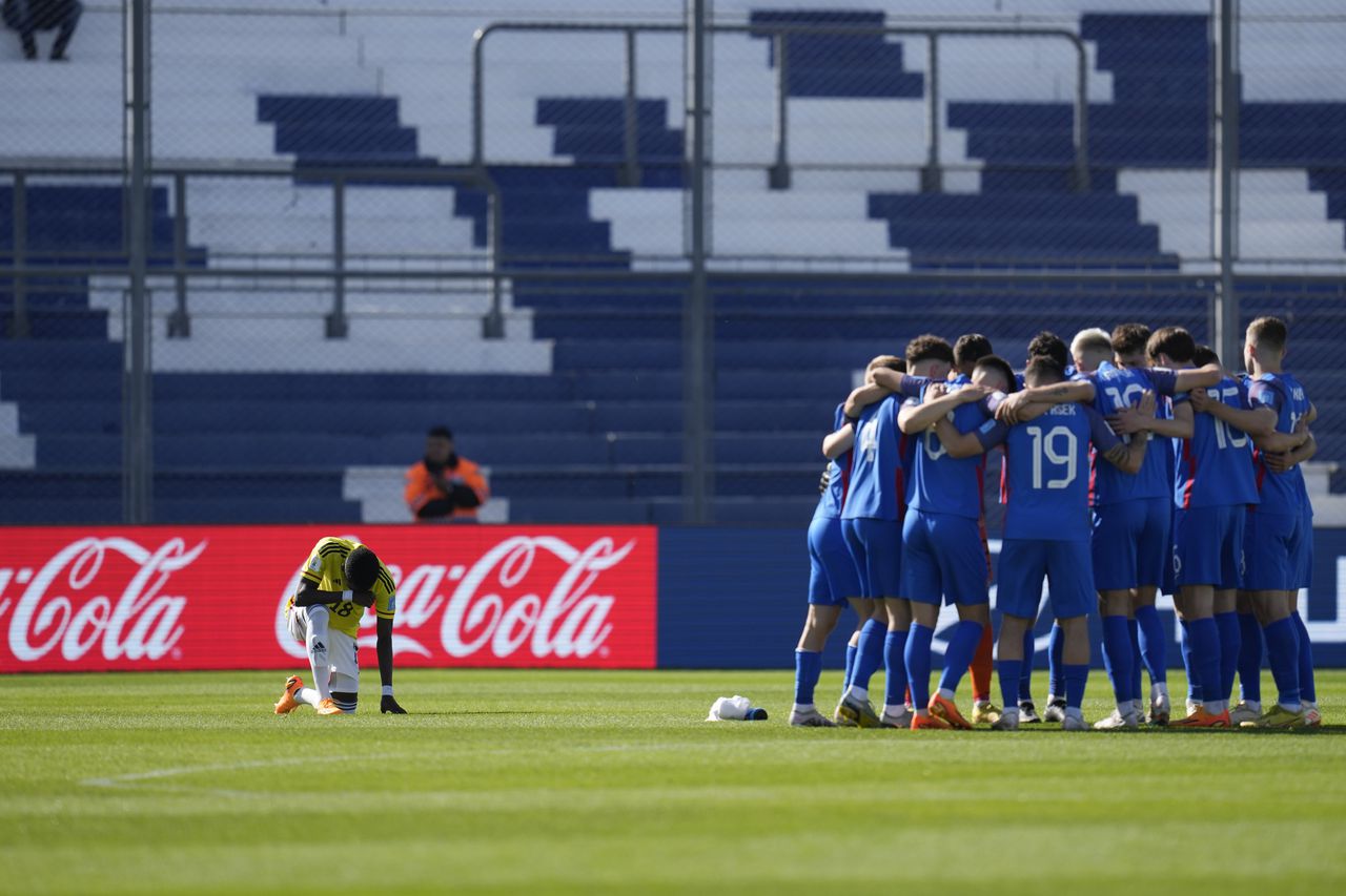 Colombia's Jhojan Torres, left, genuflects as Slovakia players gather prior to a FIFA U-20 World Cup round of 16 soccer match at the Bicentenario stadium in San Juan, Argentina, Wednesday, May 31, 2023. (AP Photo/Ricardo Mazalan)