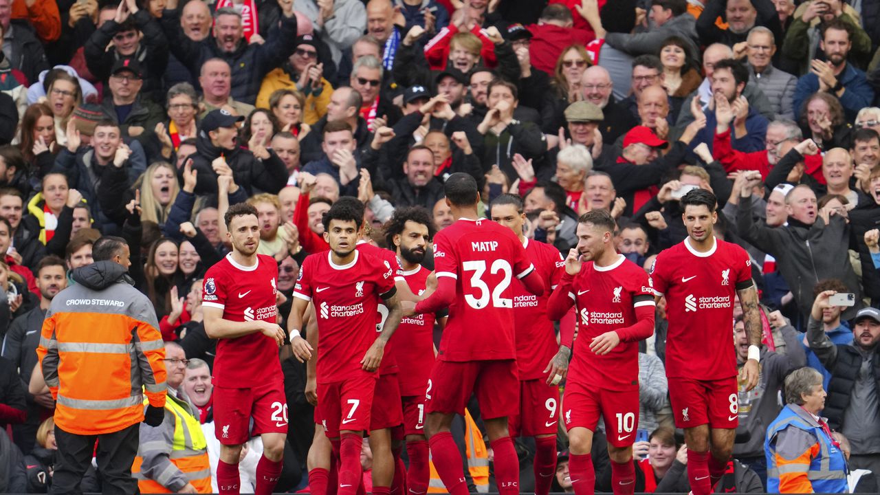 Liverpool players celebrate after Liverpool's Mohamed Salah, centre, scored his side's opening goal during the English Premier League soccer match between Liverpool and Everton, at Anfield in Liverpool, England, Saturday, Oct. 21, 2023. (AP Photo/Jon Super)