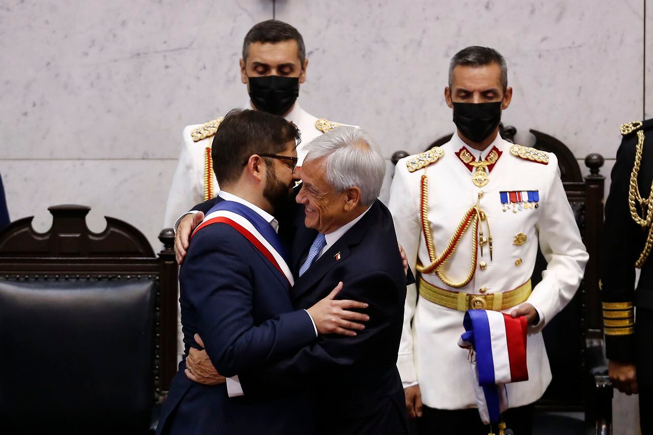 (De izquierda a derecha) El nuevo presidente de Chile, Gabriel Boric, abraza al presidente saliente de Chile, Sebastián Piñera, durante la ceremonia de inauguración presidencial en el Congreso Nacional el 11 de marzo de 2022 en Valparaíso, Chile.
