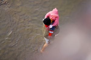 Migrantes que buscan asilo cruzan el río Bravo, la frontera entre Estados Unidos y México, para solicitar asilo en El Paso, Texas, EE. UU., visto desde Ciudad Juárez, México, 20 de diciembre de 2022. 