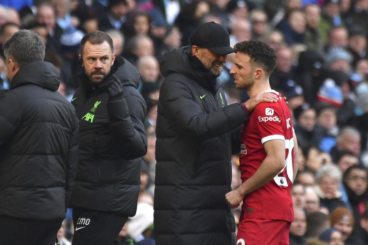 Liverpool's manager Jurgen Klopp comforts Liverpool's Diogo Jota as he walks off after being injured during the English Premier League soccer match between Manchester City and Liverpool at Etihad stadium in Manchester, England, Saturday, Nov. 25, 2023. (AP Photo/Rui Vieira)