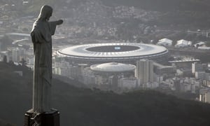 En esta foto del 13 de mayo de 2014, vista del estadio Maracaná detrás del Cristo Redentor en Río de Janeiro. Brasil será la sede de la Copa América por segunda edición seguida. (AP Foto/Felipe Dana, archivo)