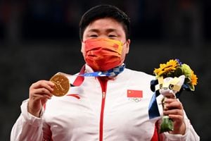 La china Gong Lijiao celebra en el podio con su medalla de oro después de ganar el evento de lanzamiento de peso femenino durante los Juegos Olímpicos de Tokio 2020 en el Estadio Olímpico de Tokio el 1 de agosto de 2021 (Foto de Ina FASSBENDER / AFP).
