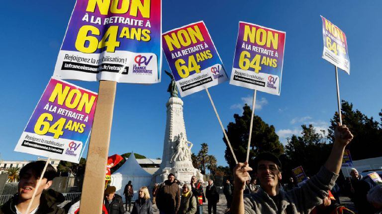 En Francia manifestantes sostienen una pancarta del partido de oposición La France Insoumise, durante una manifestación contra el plan de reforma de las pensiones.