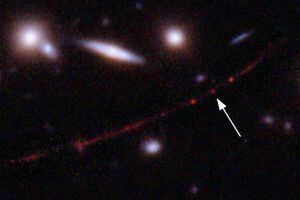 Esta imagen proporcionada por la NASA el miércoles 30 de marzo de 2022 muestra la estrella Earendel, indicada por una flecha, y la galaxia Sunrise Arc, que se extiende desde la parte inferior izquierda hasta la parte superior derecha, doblada ópticamente debido a un cúmulo de galaxias masivo entre ella y el Hubble. (NASA, ESA, Brian Welch (JHU), Dan Coe (STScI); Image processing: NASA, ESA, Alyssa Pagan (STScI) via AP)