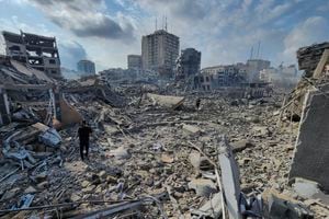 Palestinos caminan sobre los escombros de edificios destruidos por los ataque aéreos de Israel en Gaza, el martes 10 de octubre de 2023. (AP Foto/Hassan Eslaiah)