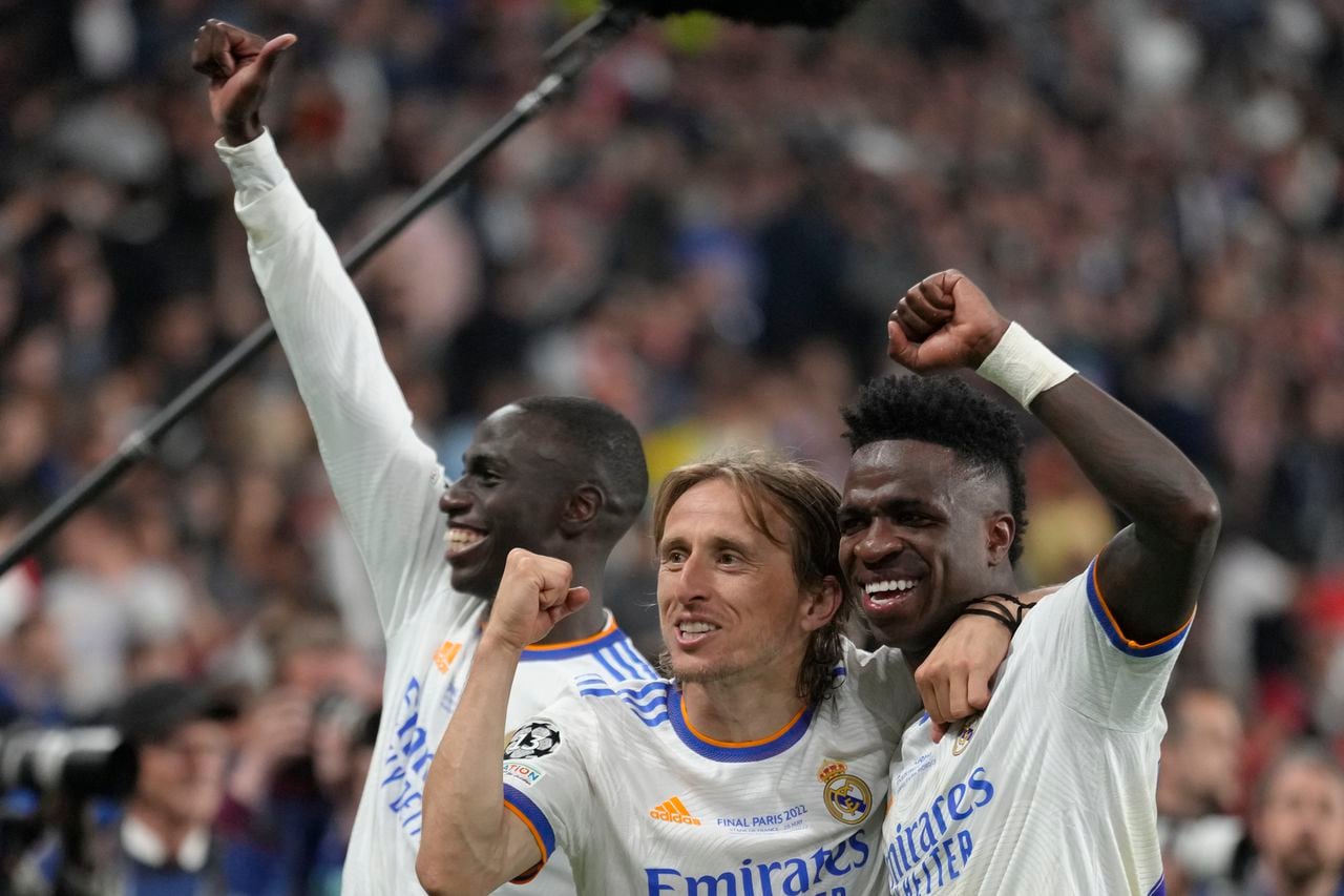 Real Madrid's Ferland Mendy, left, Real Madrid's Luka Modric, center, and Real Madrid's Vinicius Junior celebrate winning the Champions League final soccer match between Liverpool and Real Madrid at the Stade de France in Saint Denis near Paris, Saturday, May 28, 2022. Real Madrid won 1-0. (AP Photo/Kirsty Wigglesworth)